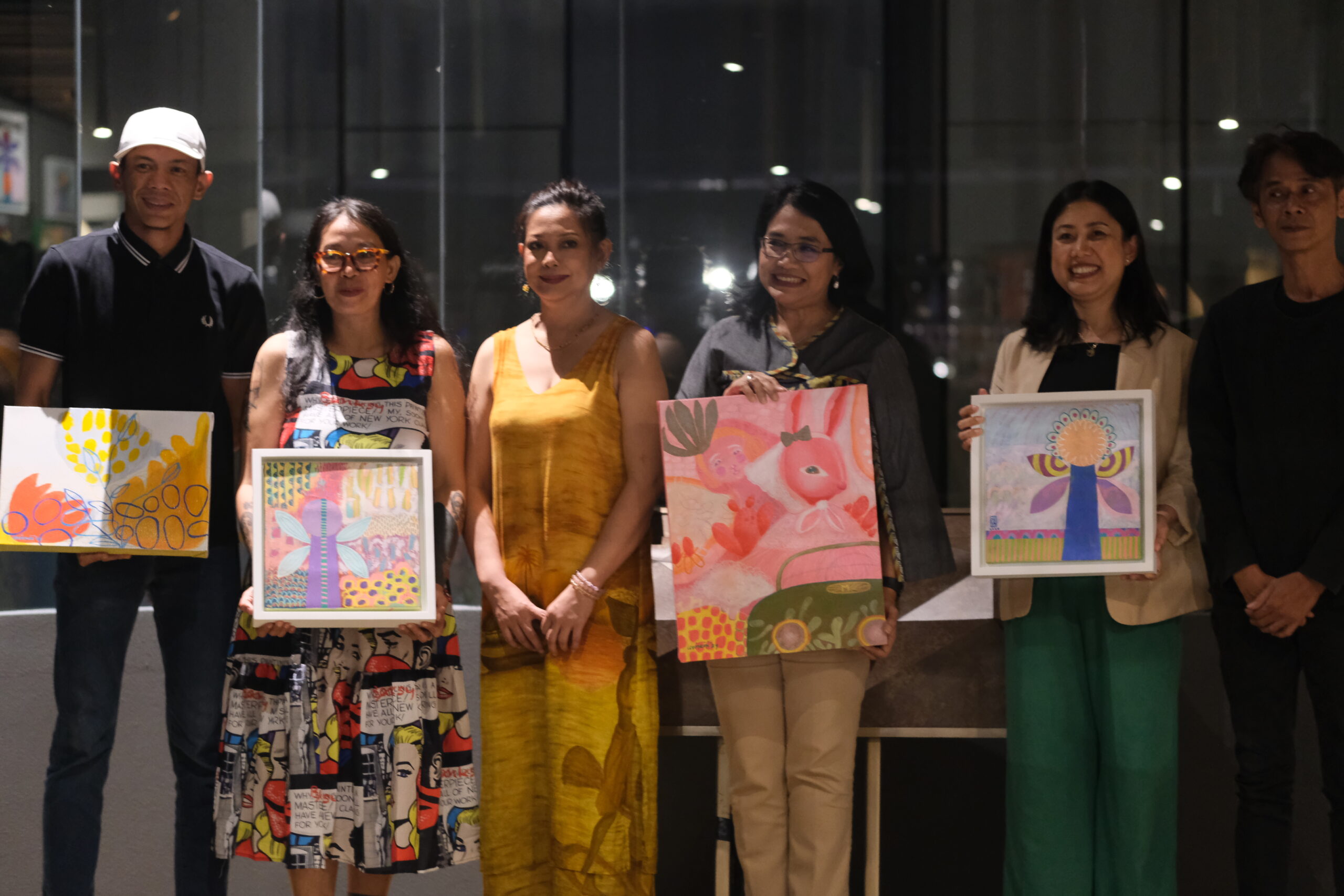 a group of people holding up paintings in PORT OF DREAM