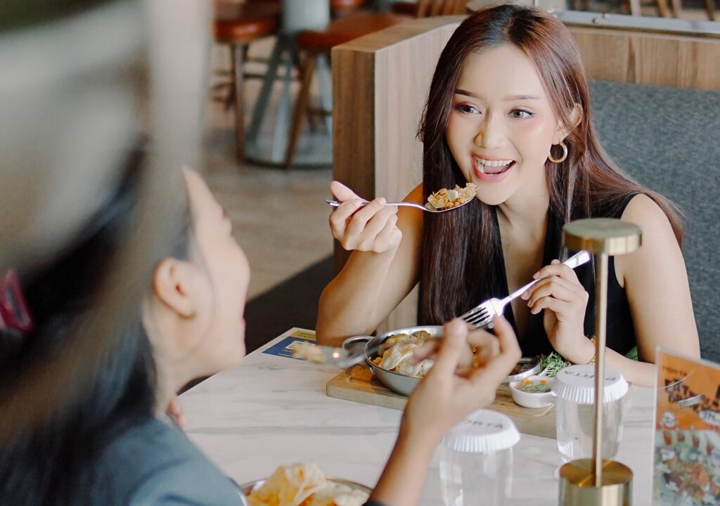 Tempat Nongkrong Seru a woman eating food at a table