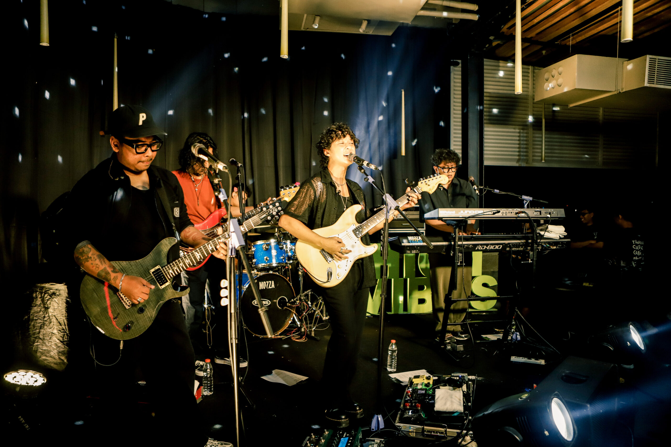 a group of people playing instruments on a stage on intimate gigs